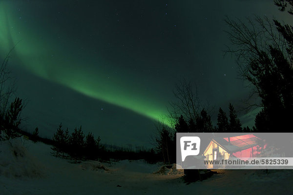 Beleuchtetes Wand-Zeltü H¸tteü mit wirbelnden Polarlichternü Aurora Borealisü gr¸nü in der Nähe von Whitehorseü Yukon Territoryü Kanada