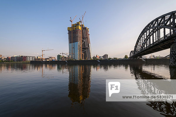 Newly constructed building of the European Central Bank  ECB  in Frankfurt am Main  at sunrise  grounds of a former wholesale market with construction cranes  Deutschherrnbruecke bridge at the back  Hesse  Germany  Europe  PublicGround