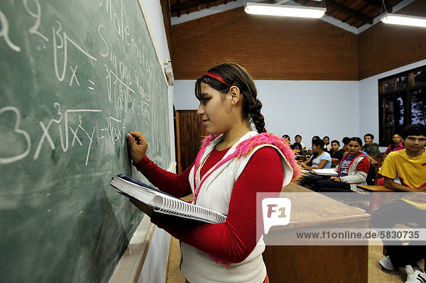 Student solving a math equation  equation on a blackboard  lessons at the agricultural college CECTEC  Itapua  Paraguay  South America