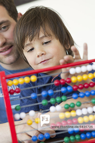 Father and son using abacus together