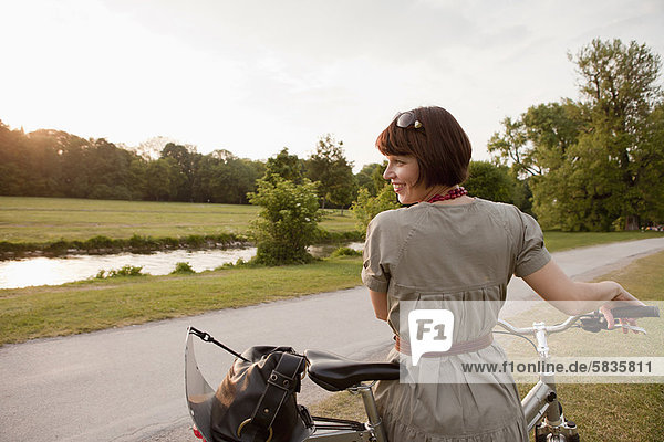 Frau mit dem Fahrrad auf dem Landweg