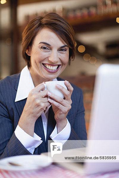 Geschäftsfrau mit Laptop im Cafe