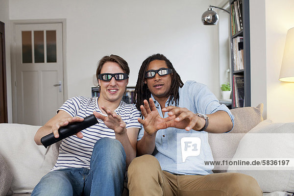 Men watching 3D television together