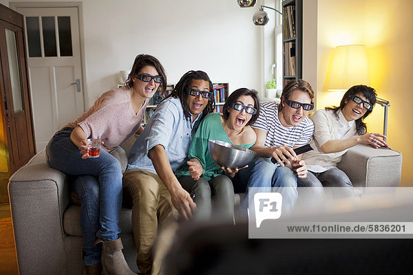 Freunde  die sich 3D-Filme im Wohnzimmer anschauen