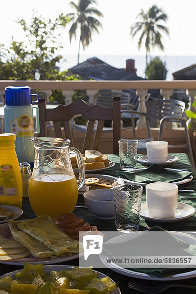 Teller und Gläser mit Essen am Tisch