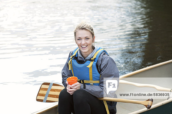 Woman having coffee in canoe