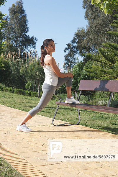 Runner stretching on park bench