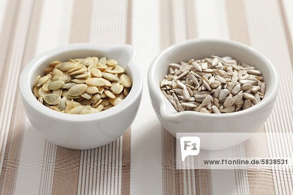 Pumpkin seeds and sunflower seeds in bowls