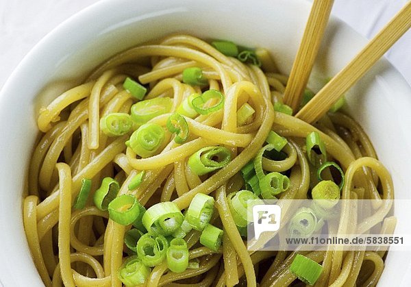 Bowl of Sesame Noodles with Sliced Scallions and Chopsticks
