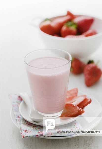 Ein Glas Erdbeermilchshake und frische Erdbeeren