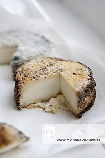 Peppered Aged Goat Cheese Wheel with Wedge Removed