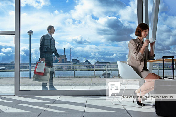 Businesswoman drinking coffee in airport