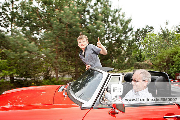Großvater und Enkel beim Fahren im Oldtimer