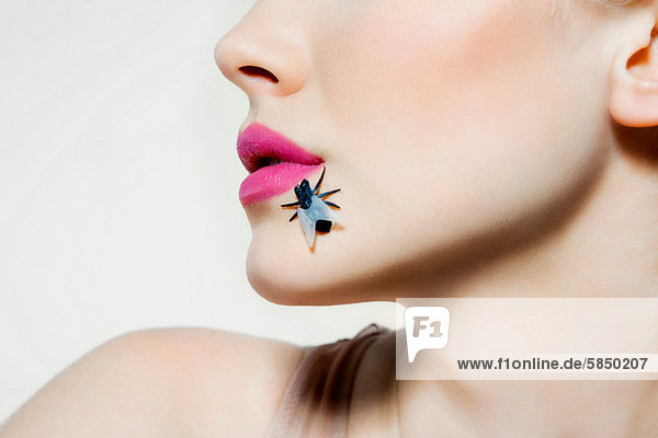 Young woman with plastic fly on face mouth