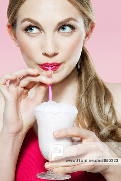 Young woman drinking milk shake