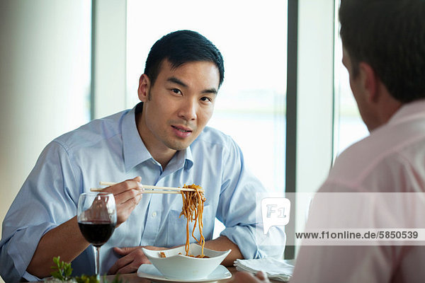 Businessman eating noodles