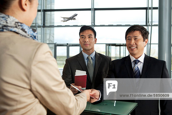 Businessmen checking in at airport