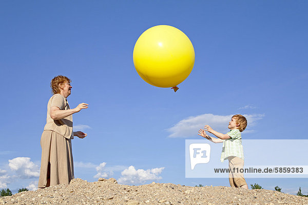 Mutter und Sohn spielen mit einem großen Luftballon