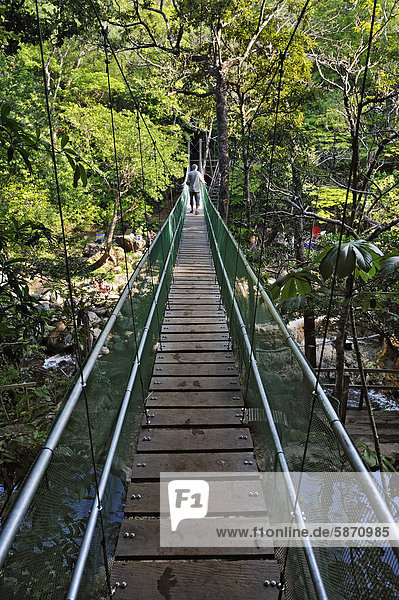 Suspension bridge leading to the hot springs near the Hacienda Guachipelin  near Liberia  Guanacaste province  Costa Rica  Central America