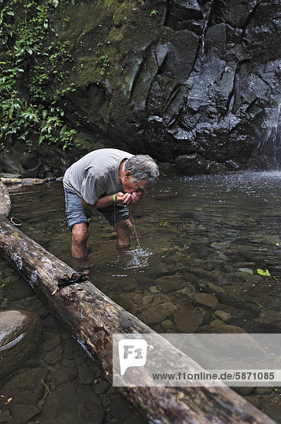 Tourist trinkt Wasser am Pool eines Wasserfalls  Nationalpark Rincon de la Vieja  Provinz Guanacaste  Costa Rica  Mittelamerika