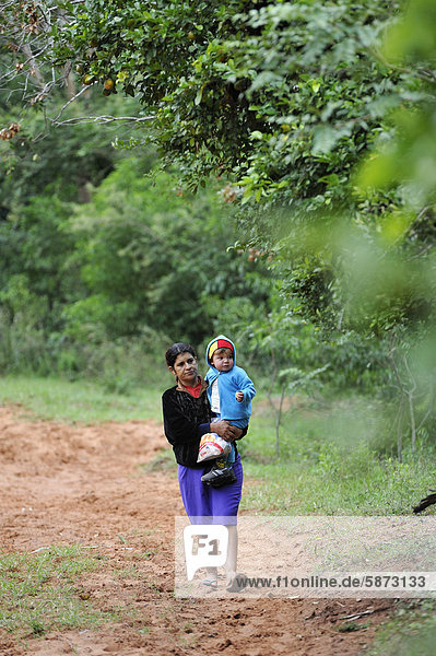 Mother carrying her child in her arms  Comunidad Kinta'i  Caaguazu  Paraguay  South America