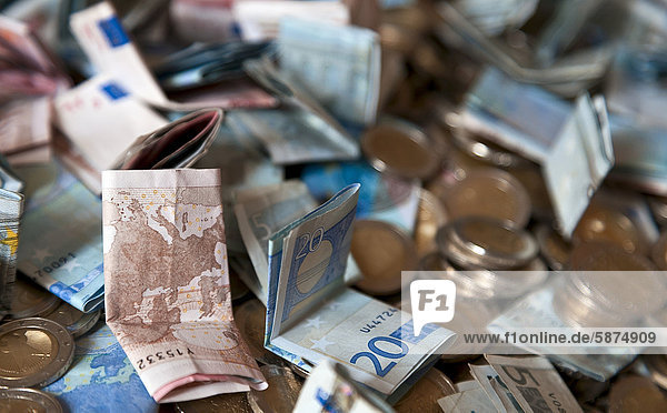 Stapel von Euroscheinen und Euromünzen