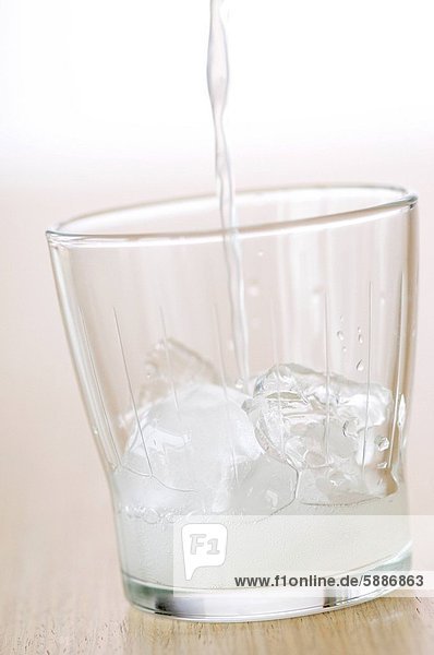 Glas eingießen einschenken füllen füllt füllend Eis Zitrusfrucht Zitrone würfelförmig Würfel Cola