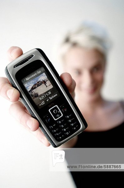 Portrait einer jungen Frau die ein Mobiltelefon
