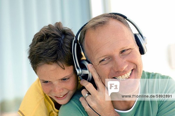 hinter Mann zuhören lächeln Sohn Kopfhörer Musik reifer Erwachsene reife Erwachsene Kleidung Klassisches Konzert Klassik