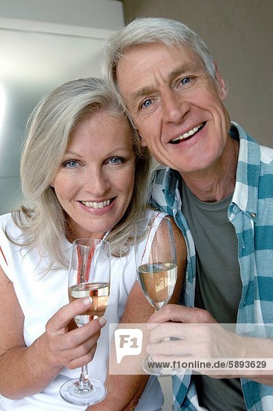 Porträt eines ausgereiften Paares hält Champagne Flöten und lächelnd
