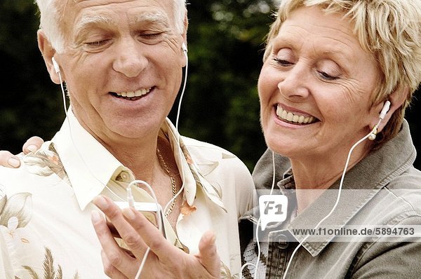 Senior  Senioren  zuhören  lächeln  Kopfhörer  Musik