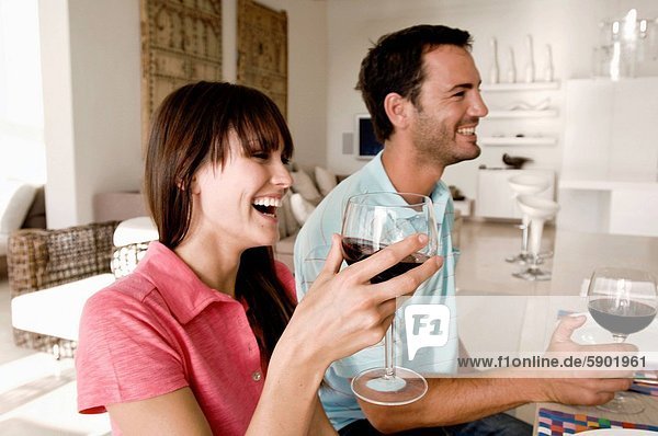 Side profile of a young couple holding wine glasses and smiling