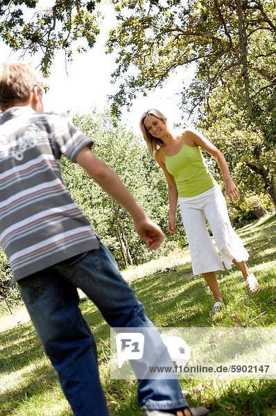 Frau Sohn Mittelpunkt Fußball Erwachsener spielen