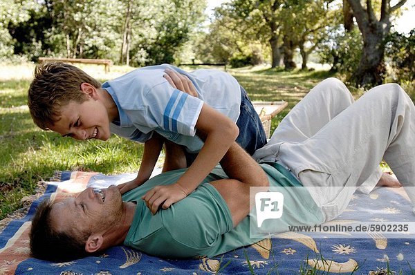 Side profile of a mid adult man playing with his son in a park