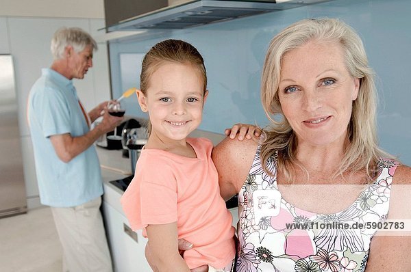 Senior Senioren kochen Portrait Frau Mann tragen Hintergrund Enkeltochter