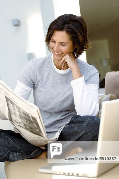 sitzend  Frau  reifer Erwachsene  reife Erwachsene  Couch  Zeitung  vorlesen