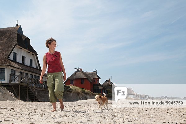 Frau mit Hund am Strand in Graswarder  Schleswig-Holstein  Deutschland