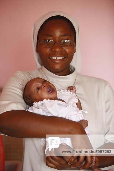 Franciscan sister holding an orphan at nursery and kindergarten run by Catholic nuns  Lome  Togo  West Africa  Africa