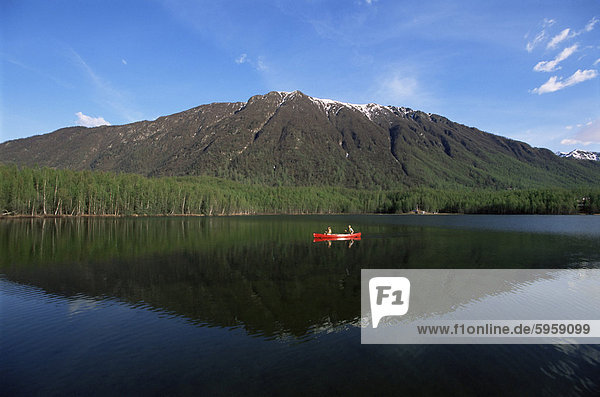 Man and woman canoeing in Mirror Lake  Chugach Mountains  Anchorage  Alaska  United States of America  North America