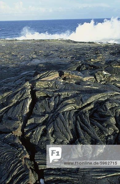Fresh pahoehoe or ropey lava  close to where steam rises from lava entering the sea on the southeast Puna coast  Big Island  Hawaii  Hawaiian Islands  United States of America  Pacific  North America
