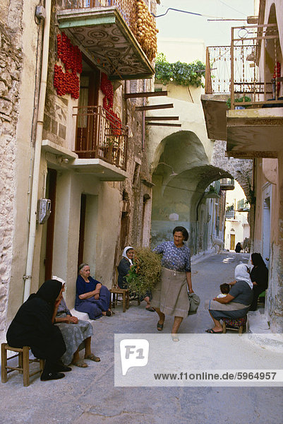Women gathering on the doorsteps in the early evening along the narrow back streets of the old mastic village of Pyrgi Chios North Aegean Islands Greek Islands Greece Europe