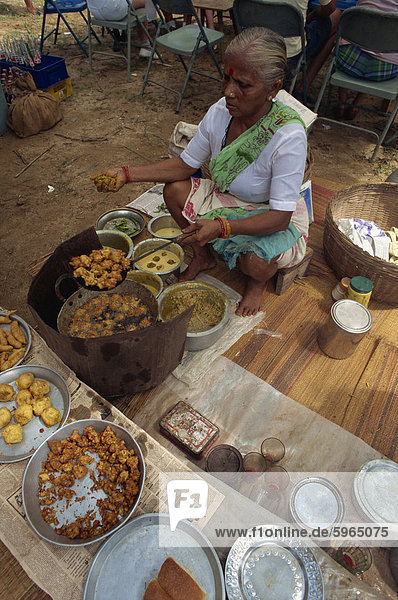 Erhöhte Ansicht einer indischen Frau sitzen Kochen Zwiebel-Bhajis zum Verkauf an einer Garküche in einem Markt  Goa  Indien  Asien