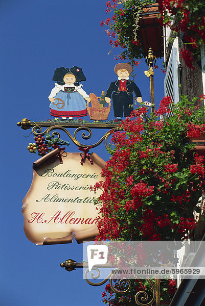Sign außerhalb traditioneller Patisserie  rote Blumen Prominente  Eguisheim  Haut-Rhin  Elsass  Frankreich  Europa