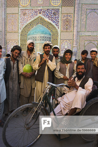 Behinderte Mann sitzt in speziellen modifizierten Fahrrad umgeben von Männern außerhalb Schrein von Hazrat Ali  Mazar-I-Sharif  Provinz Balkh  Afghanistan  Asien