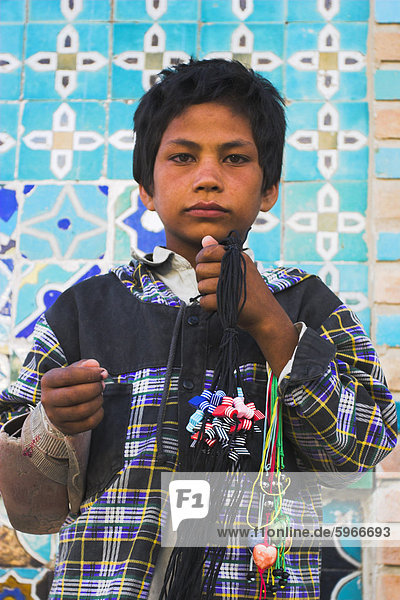 Street boy selling necklaces at the Shrine of Hazrat Ali  Mazar-I-Sharif  Balkh province  Afghanistan  Asia