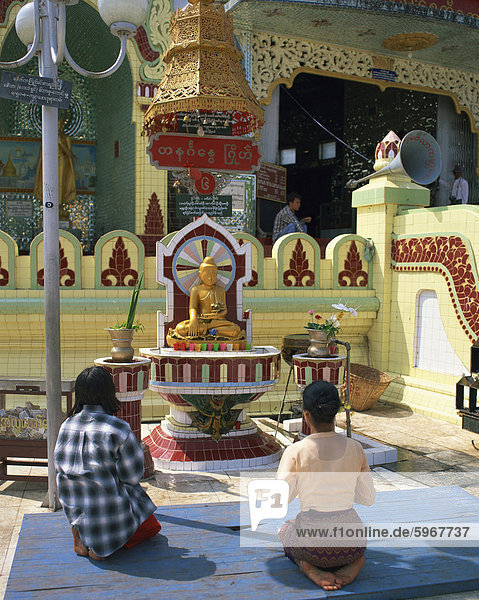 Two people praying at a pagoda  Yangon (Rangoon)  Myanmar (Burma)  Asia