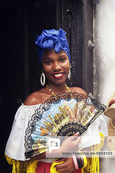 Junge Frau im typischen kubanischen Kleid hält eine Fan Habana Vieja Havanna Kuba Westindische Inseln Mittelamerika