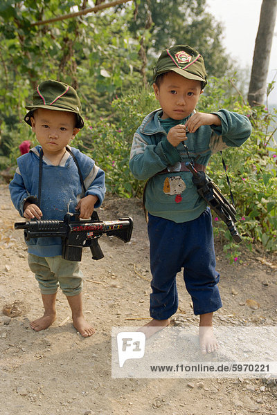Portrait of two boys with modern toy guns in Guizhou  China  Asia