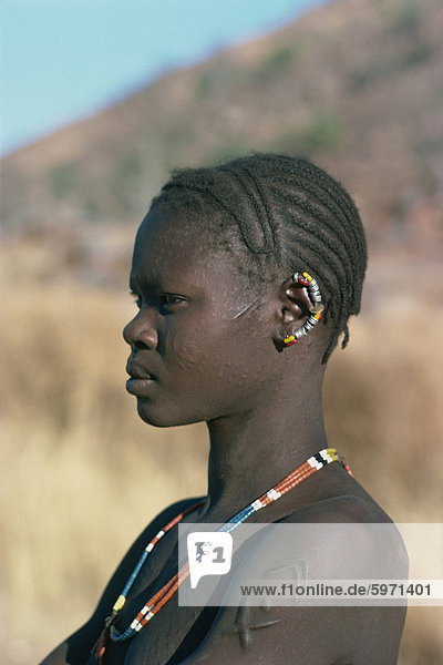 Portrait of Nuba woman with earrings and scars  Sudan  Africa