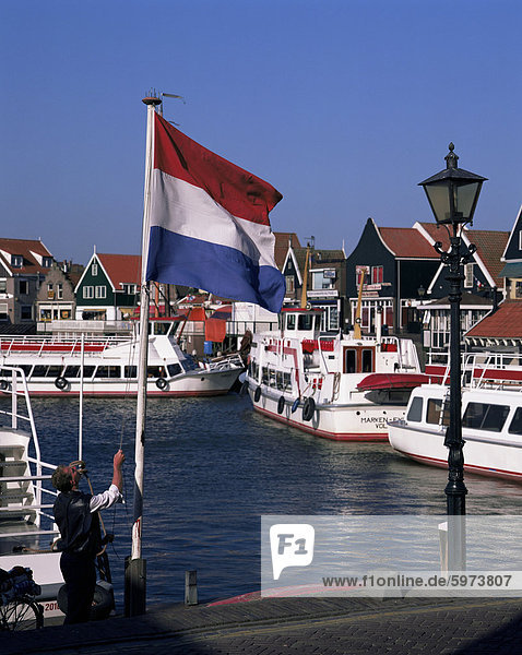 Raising the Dutch flag by the harbour  Volendam  IJsselmeer  Holland  Europe